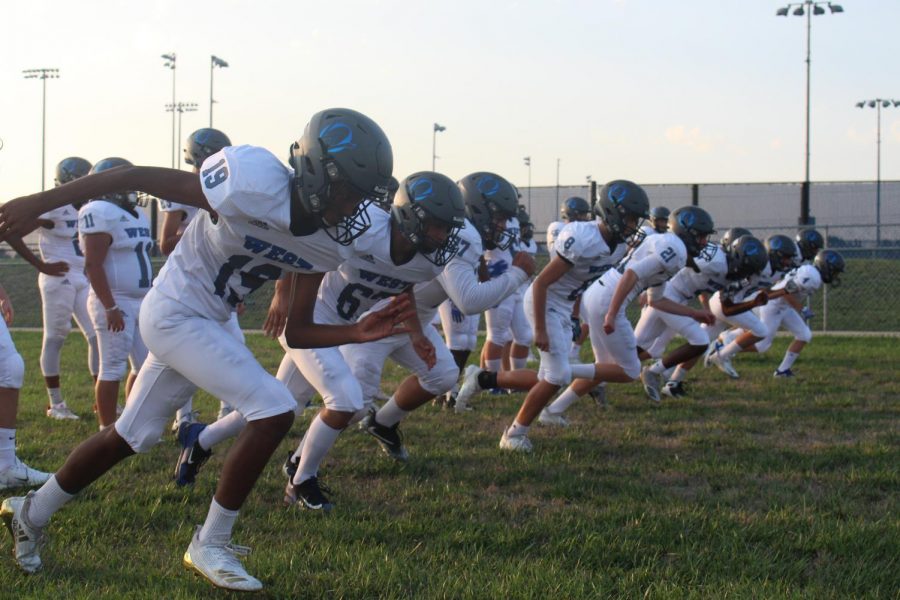 The freshman football team warm up for the upcoming scrimmage.