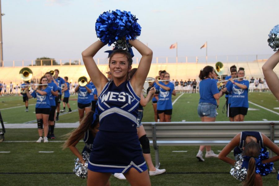 Haley McMullen performs the fight song with the rest of the cheer squad at Friday Night Lights, an event to kick off the season.

Caption: Alivia Goodlow