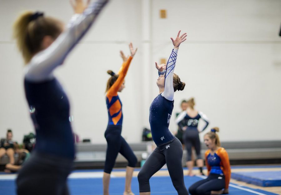 Olathe West Varsity Gymnastics team warms up alongside Olathe Easts team before their performance on Sept.13. While Olathe East and Olathe West share a coach, they also compete against one another.