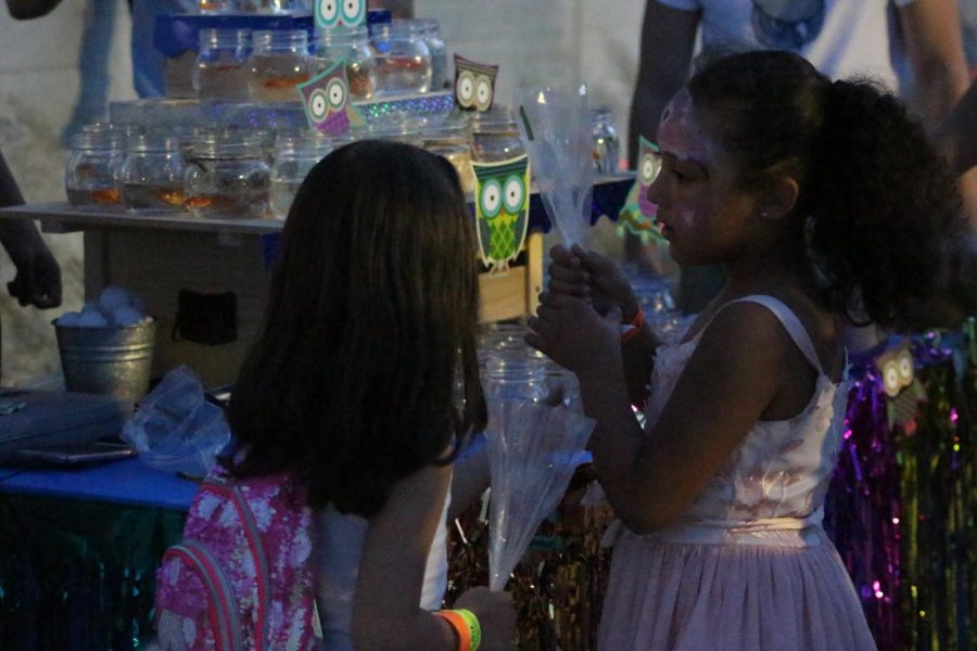 In this photo two little girls are picking out the fish they won at the carnival. 