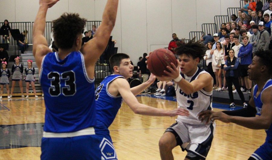 Junior Cougar Downing drives the ball towards the hoop during the Owls losing game.