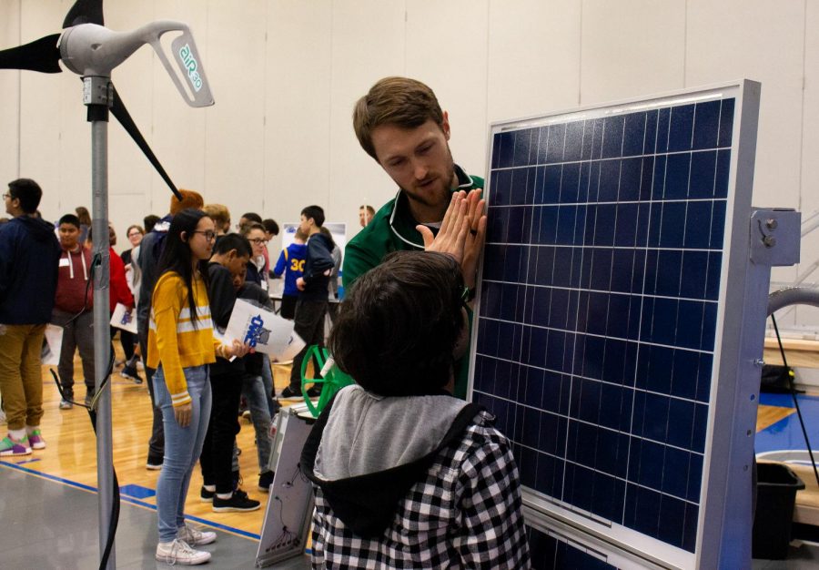 Green Tech facilitator Cody Janousek introduces the 21st Century program to a future freshman on Eighth Grade Transition Day. Janousek explains how solar panels, such as the ones outside of West, function and do their job.