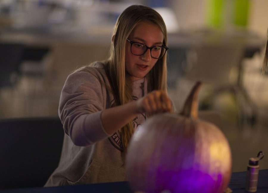 Sophomore Kaitlyn McDonald focuses in on her pumpkin at the Oct. 26 pumpkin painting party for the JV Cheerleaders.