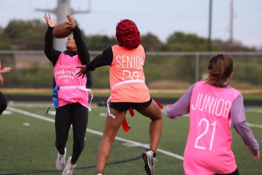 Junior Alyssa Moore jumps to catch a ball thrown during the first half of the Powder puff game on Thursday Oct.3.