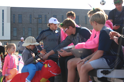 Junior Ryan Sauter hands out candy to young trunk-or-treaters while sitting on the tailgate at the soccer trunk. 