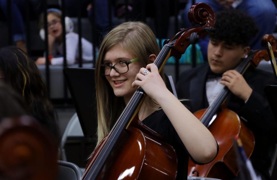 Junior Ella Powell plays the cello as family and friends of the orchestra watch.