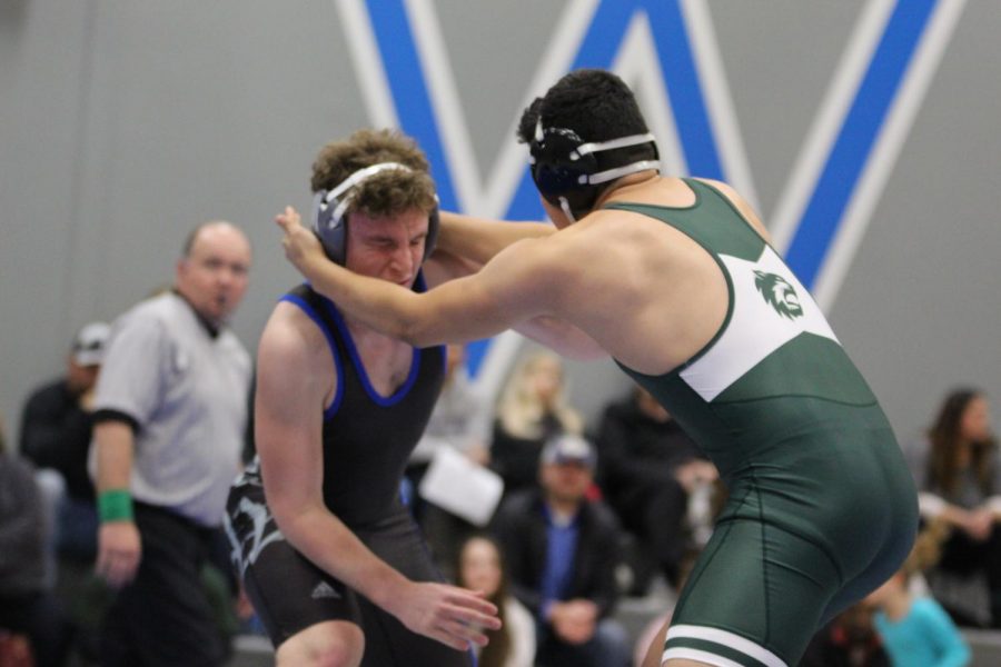 Junior Colby Karnei defends himself against his opponent from DeSoto. Typically, both girls and boys wrestling compete on the same night, but DeSoto did not have a female team. 