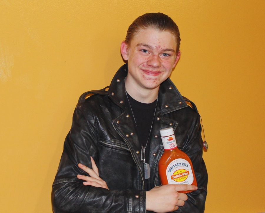 Matthew Goans poses with his signature leather jacket and a bottle of Buffalo sauce: the inspiration behind his nickname, Sssauce.