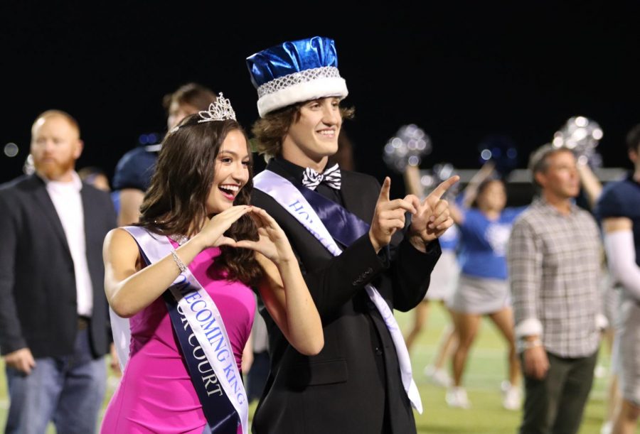 Homecoming Queen Sophie Schneider and Homecoming King Stone El-Attrache pose for photos after being announced the winners of the homecoming royalty vote at the game on Friday.