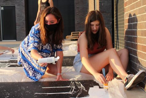 Stuco members sophomores Kolby Brown and Megan Ulrich paint city skylines for the homecoming dance decorations.