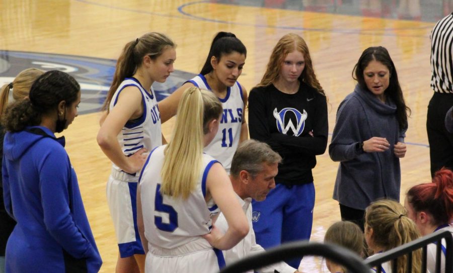 Varsity girls team talks on the bench during a timeout in their home game against Shawnee Mission North on Jan 11.
