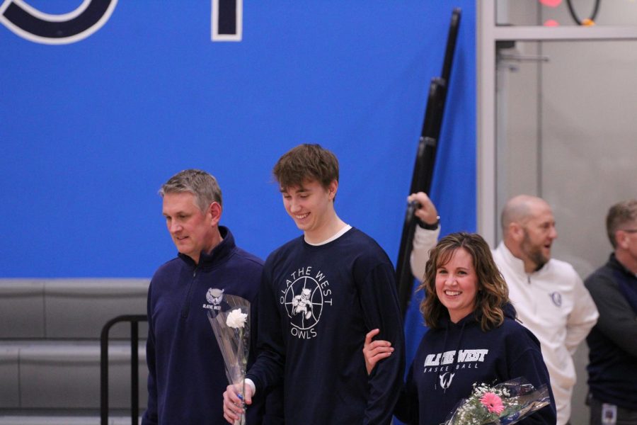 Senior Jayson Luse walks the court with his parents for the senior night ceremony. The Boys team won their game with a score of 62-52, the girls also won their game with a score of 49-44.