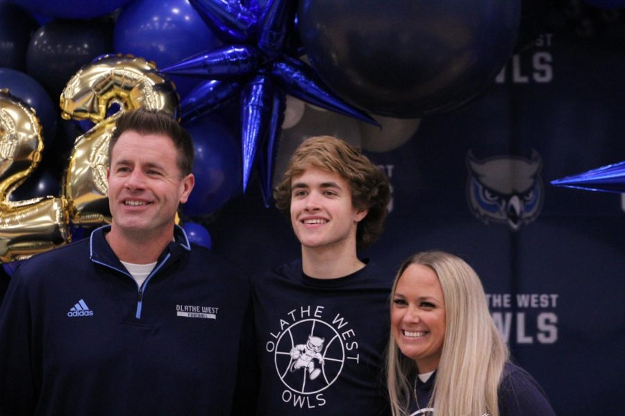Senior Brisyn Robinson poses for a picture with his parents during the senior night ceremony. Olathe West played Shawnee Mission East at their last home game of the season.