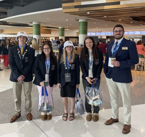 Sophomore Alexander Stone, Neu, Clinkinbeard, Roberts, and DECA coach Mr.Nill all got pins for Kansas which they then got to trade with other states at Nationals. You can see the pins placed on their lanyards. Clinkinbeard said she found this tradition fun and unique. 
