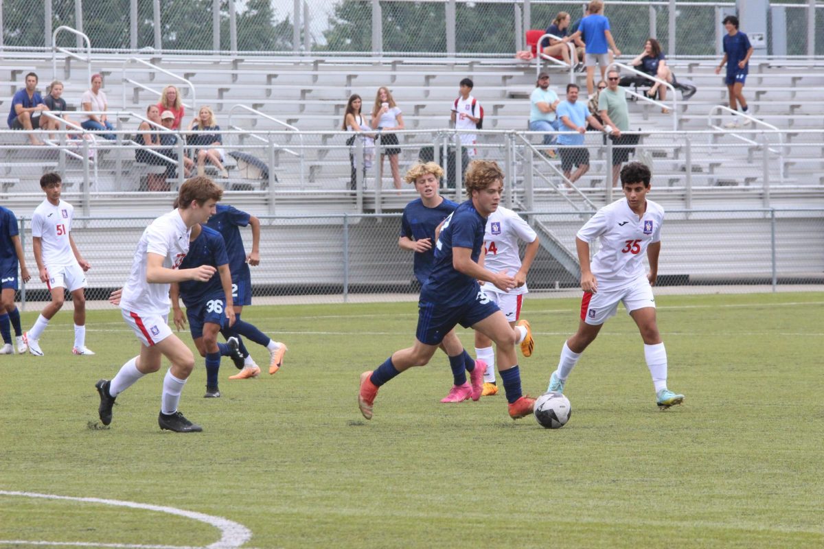 At the top of the 18 yard box, freshman Thomas Toth is surrounded by Pembroke Hill defenders as he tries to score a goal.
