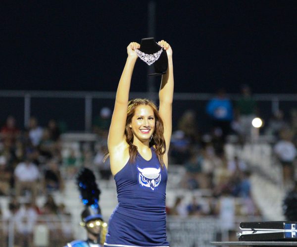 Junior dance team member Anita Reyna holds up the necklace at the end of the field show “The Heist”.