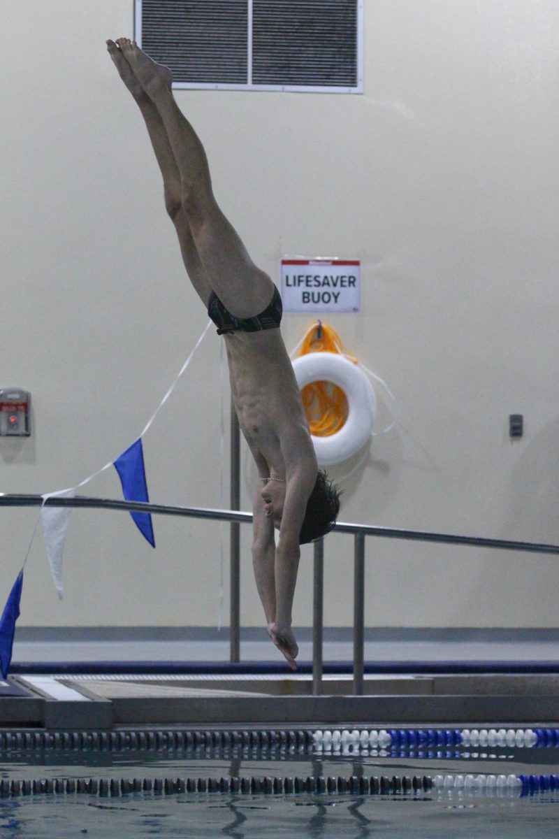 Sophomore Eli Mills dives against two other students from St. James High School.
