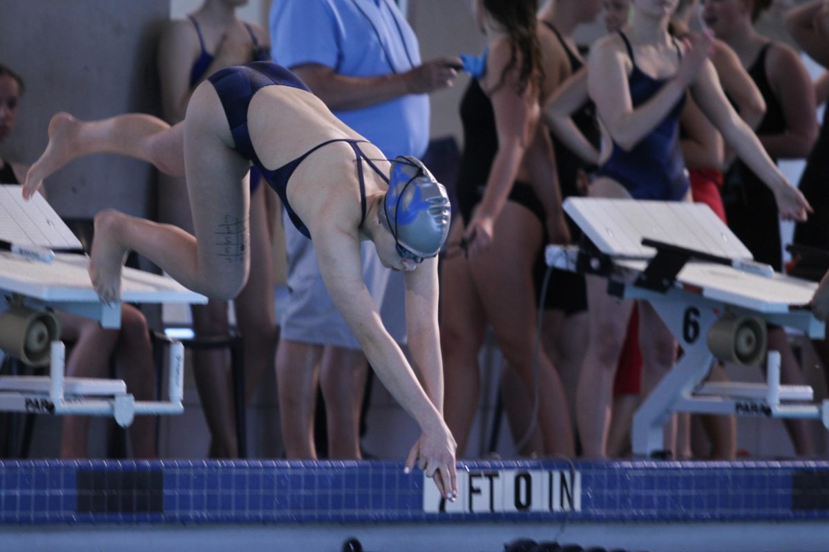 Freshman Lexi Hayden kicks off to start her swim.