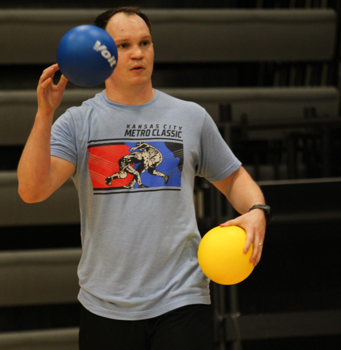 Special Education teacher Zach Russman collects the balls before throwing them during a game.