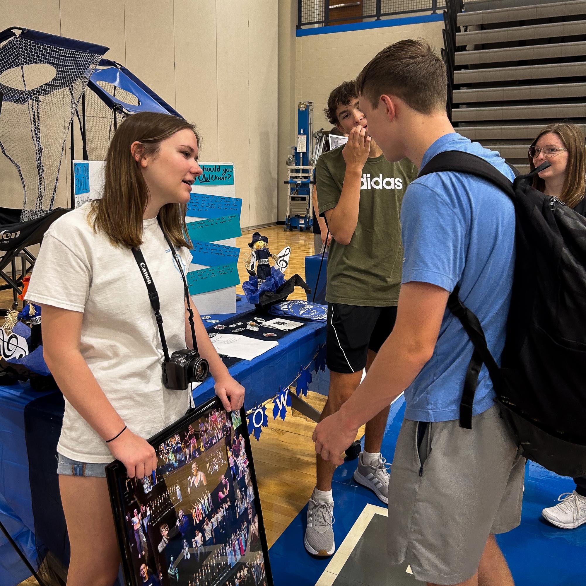 Junior Addy Davis talks about choir to students at the activity fair.