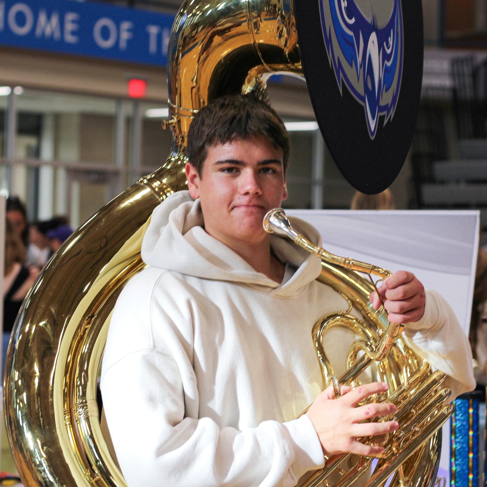 Junior Owen Twaddell poses with sousaphone at the band activity fair booth.