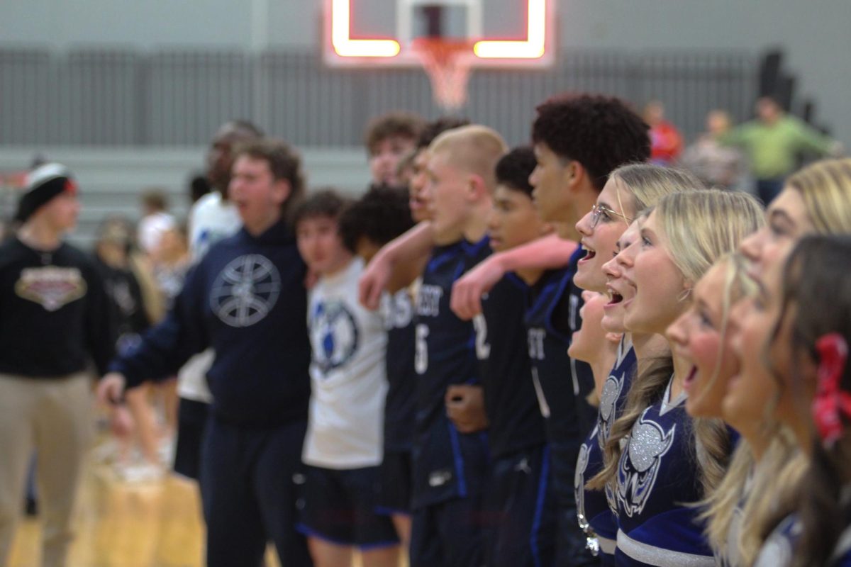 The cheerleaders and players sing the Olathe West Alma Mater after the win against Olathe Northwest