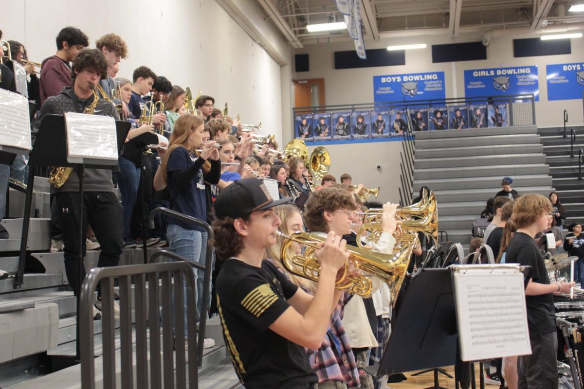 The marching band plays music as the eighth graders enter the school.