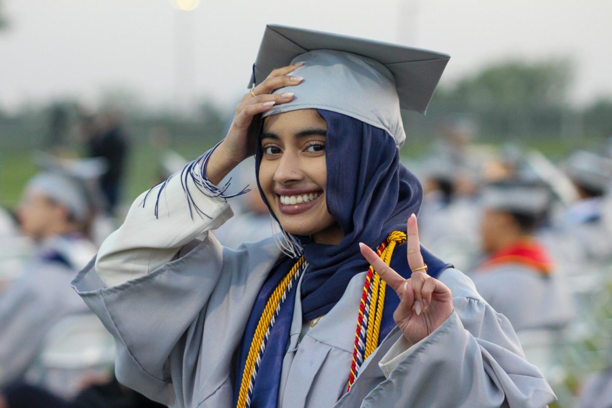 Senior Fatima Khalid is seen smiling and doing a peace sign at the camera.