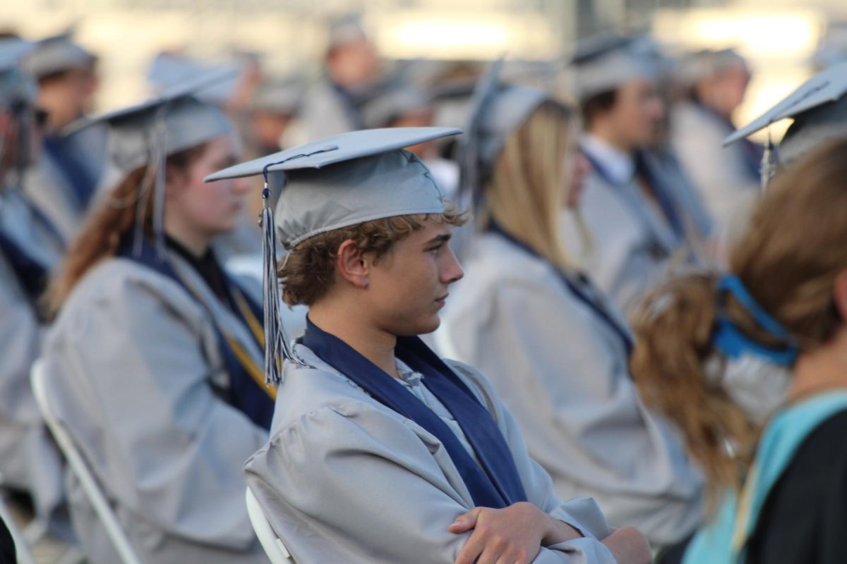 Senior Eli Resch listens to a speech being given on stage.