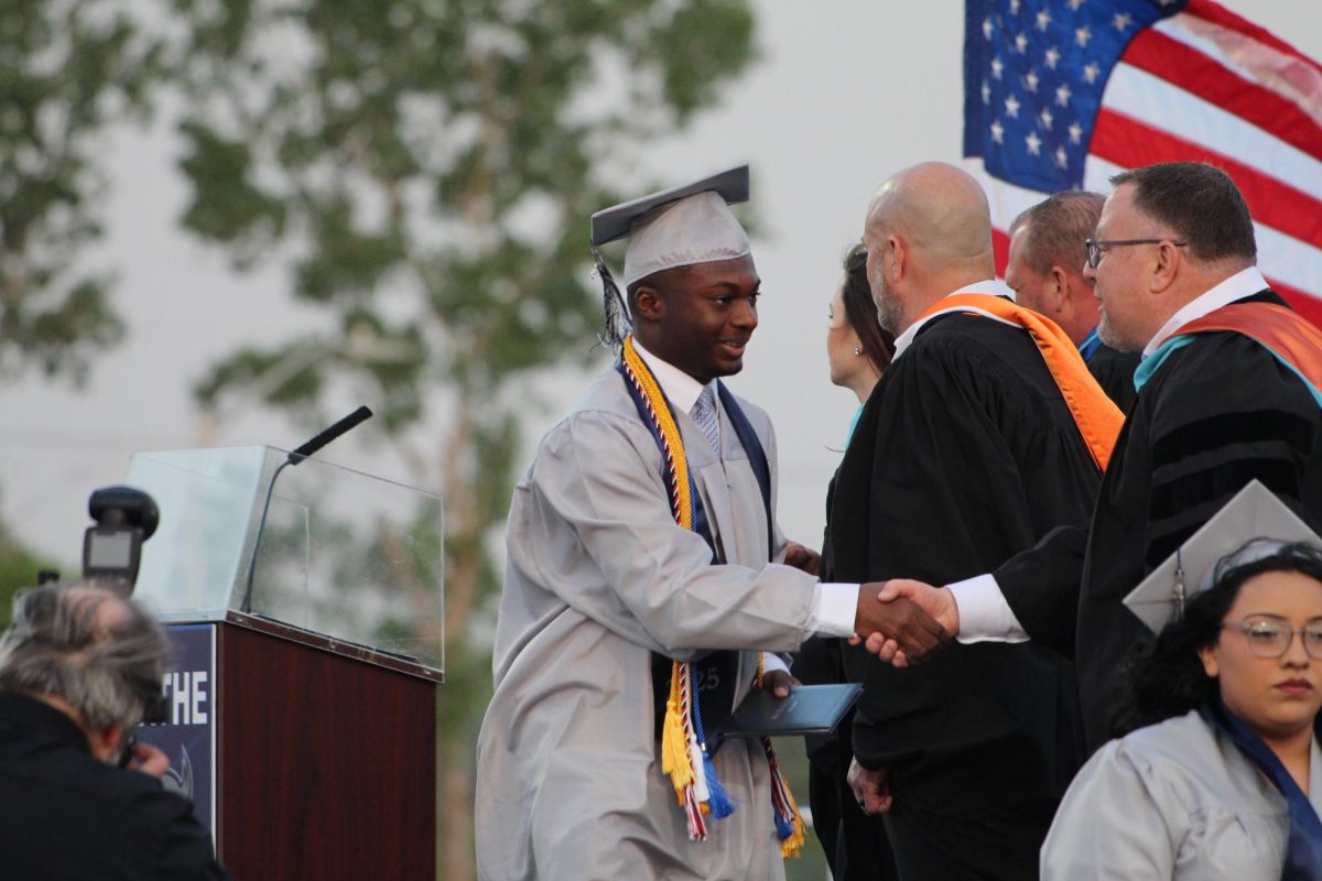 Senior Ezekiel Bechie shakes hands with Superintendent Brent Yeager.