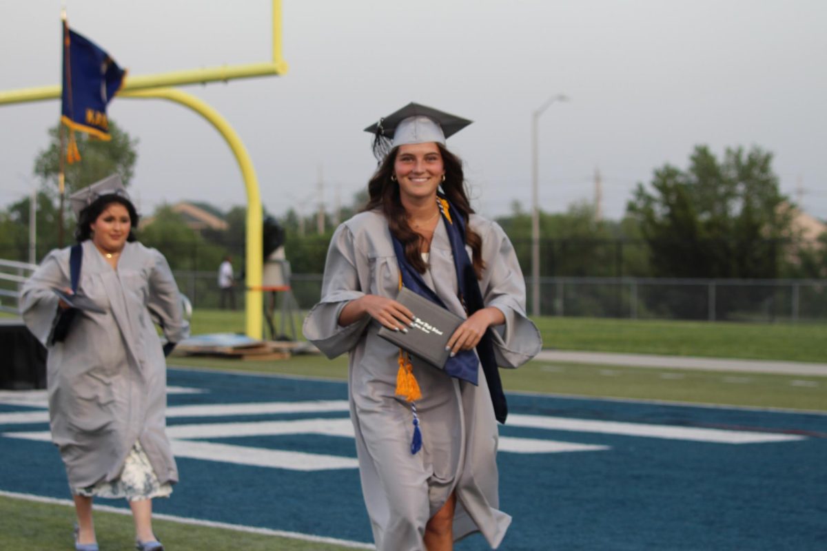 Senior --- smiles at the camera after receiving her diploma.
