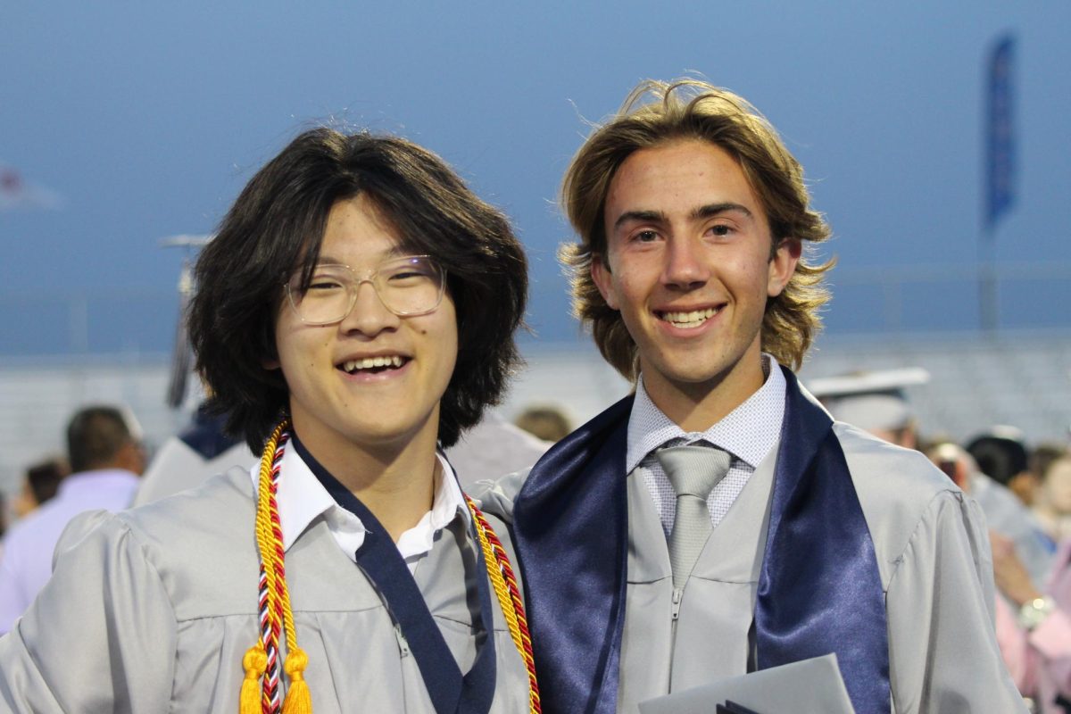 Seniors Braxton Theel and Tai Fenton smile together after the graduation ceremony.