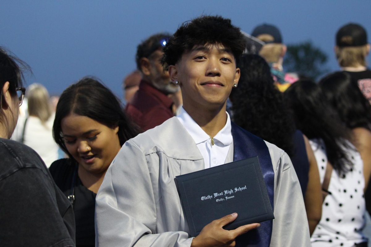 Senior Chase Keopraseuth smiles at the camera after the graduation ceremony.
