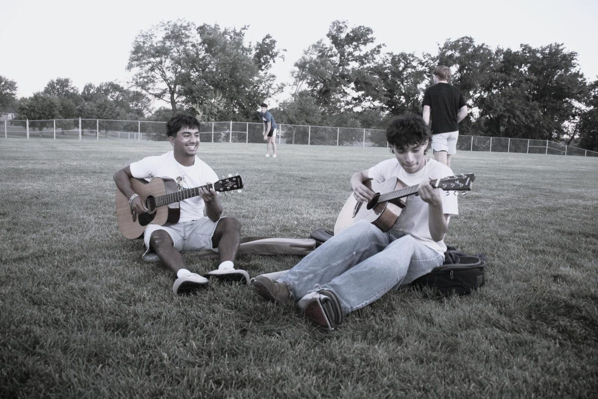From left, Alex Valdes and Daniel Reyes playing guitar together.