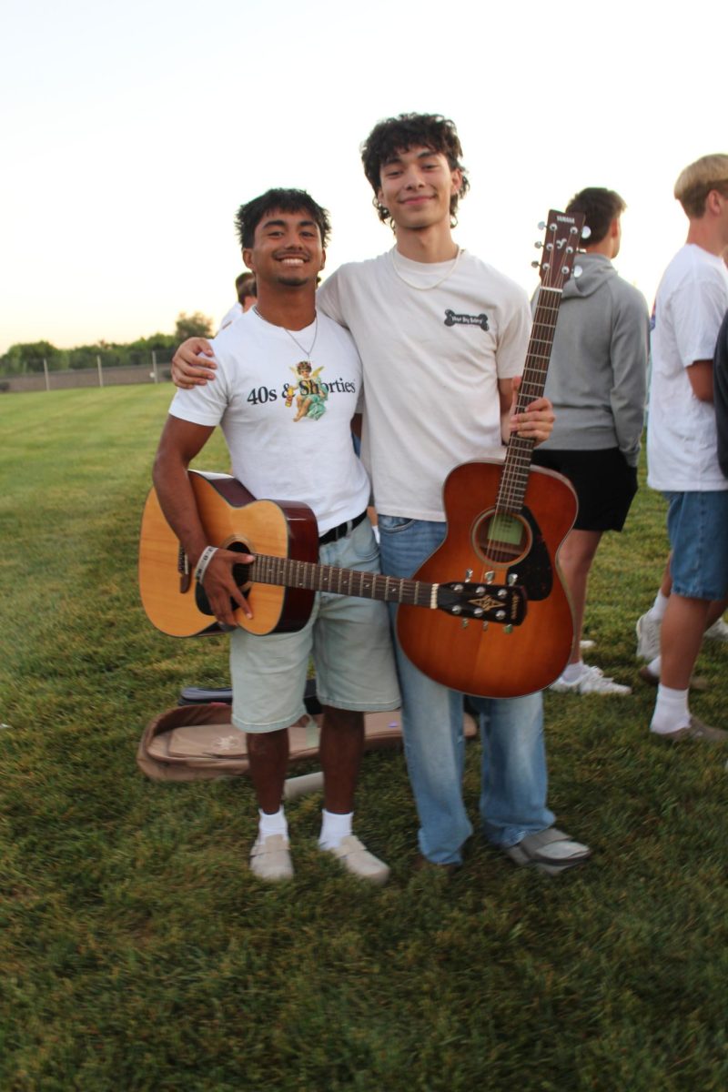 Alex Valdez and Daniel Reyes smiling for the camera with their guitars.