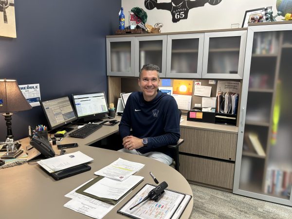 Assistant Principal Heath Sigg sitting at his new desk in the junior office.