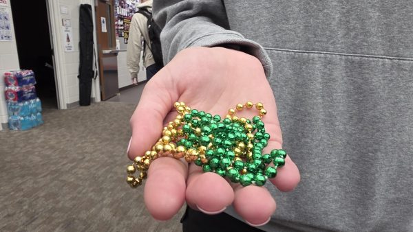 Roshambo day multicolored beads being held by a winning student.