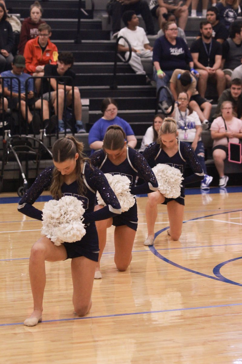 Reagan Jackson, Brooke Bennett, Halle Morrow performing team pom for students