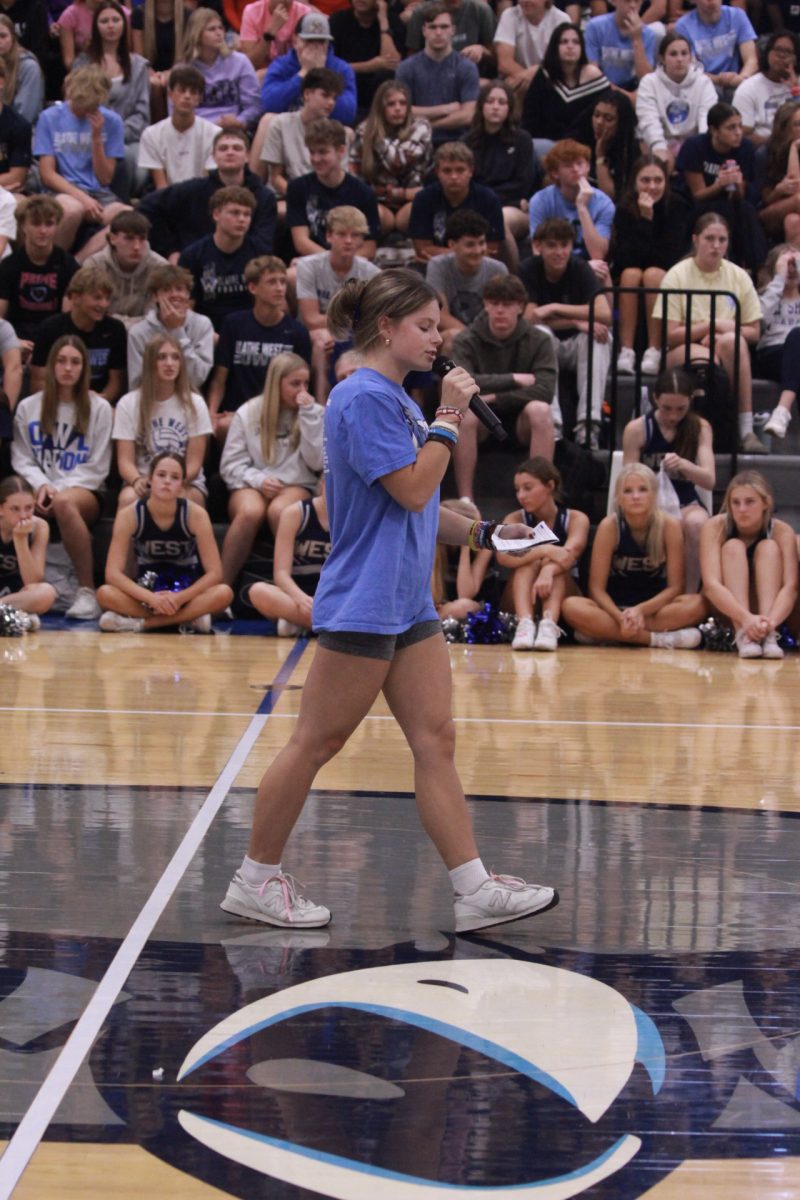 Kennedy Heideman speaking to students about homecoming at the pep assembly
