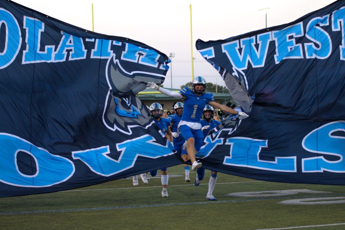 Senior Slate Swinford bursts through the banner before the game Vs Gardner-Edgerton
