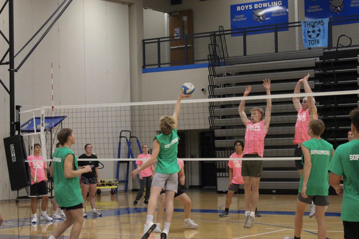 The sophomore team hits the ball to the senior team.