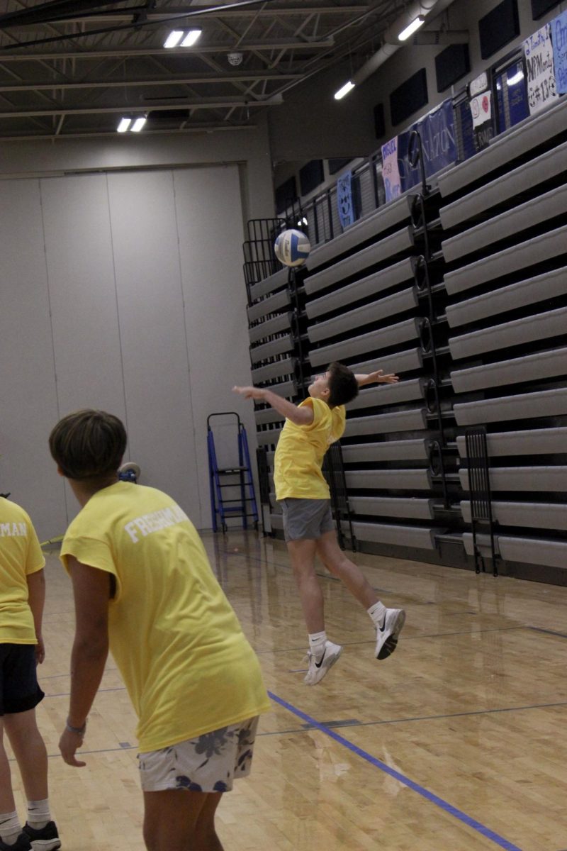 The freshman team serves the ball.