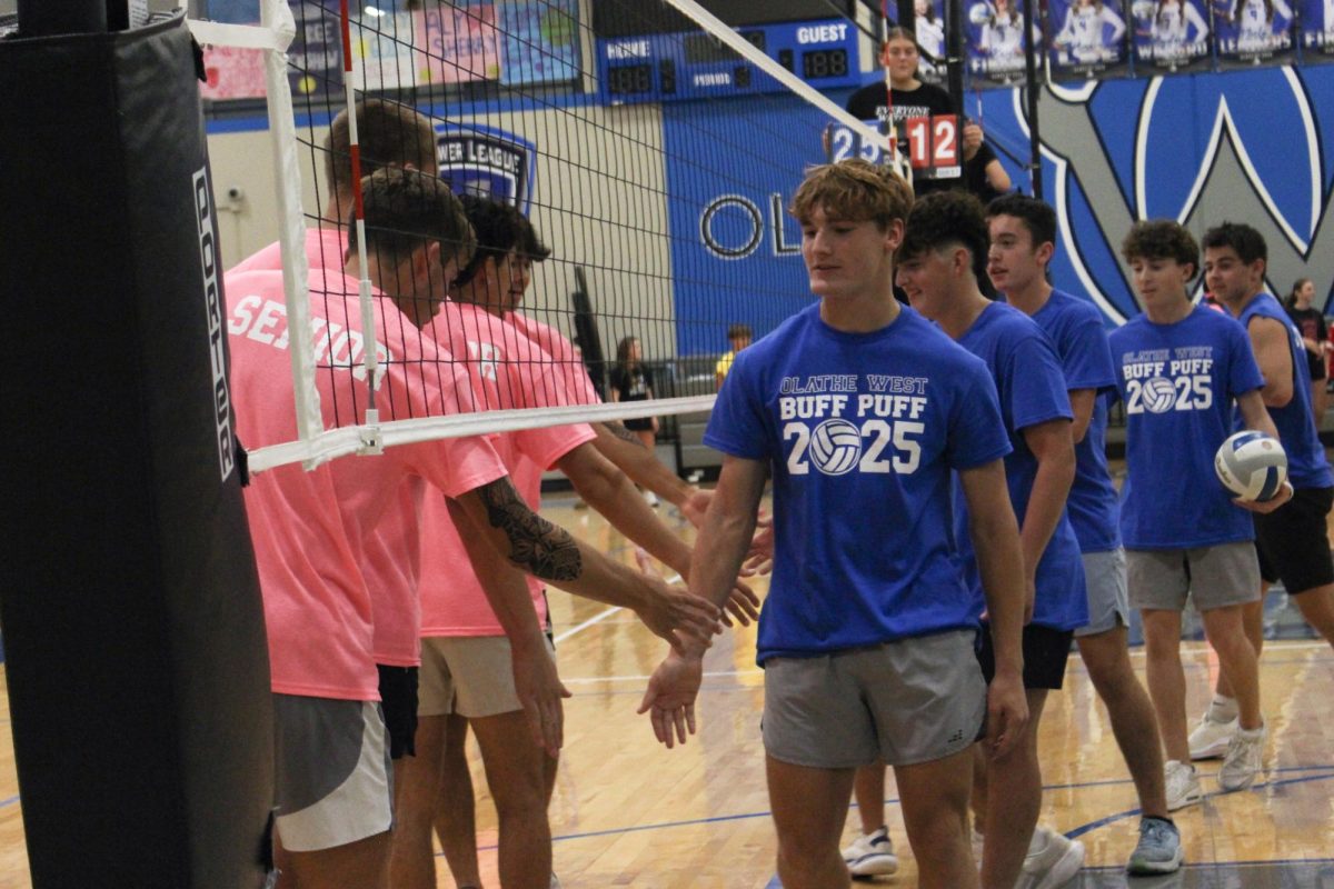 Junior and senior teams shake hands after a match.