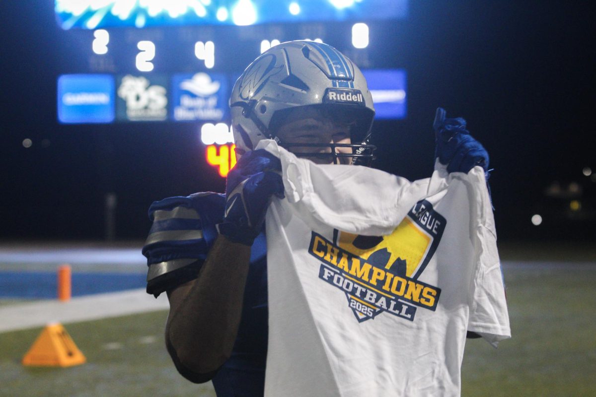 Senior Josh Foland holds up the championship shirt after the victory against Olathe Northwest