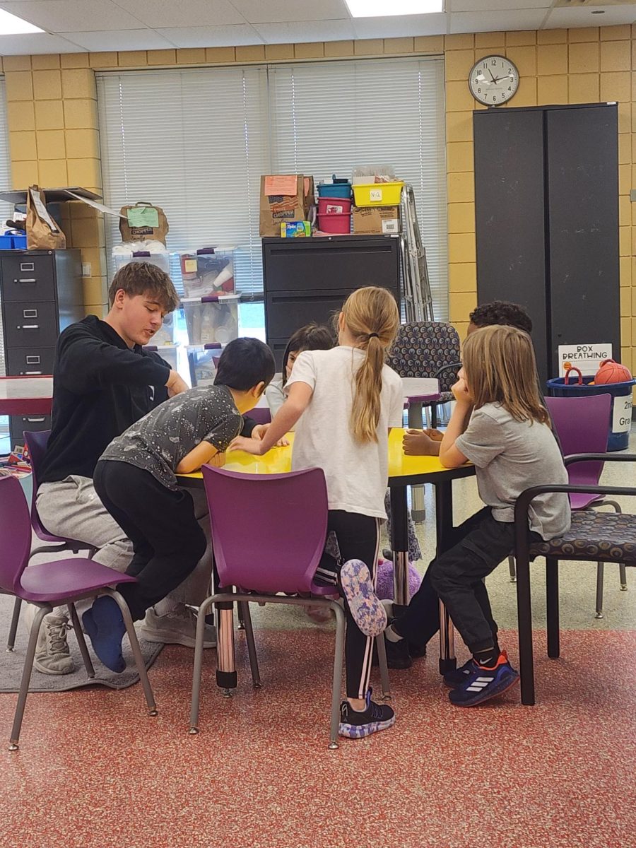 Senior Landon Goetz playing board games with Clearwater Creek kids.