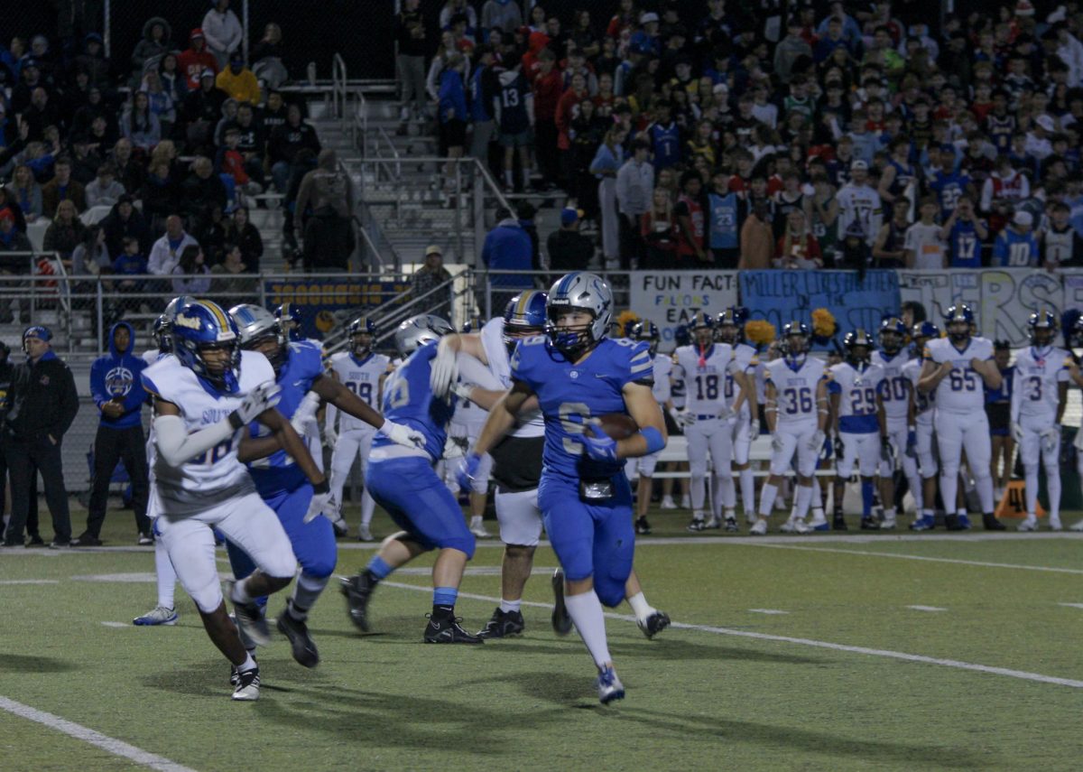 Senior Josh Foland tries to run away from Falcons' defenders 