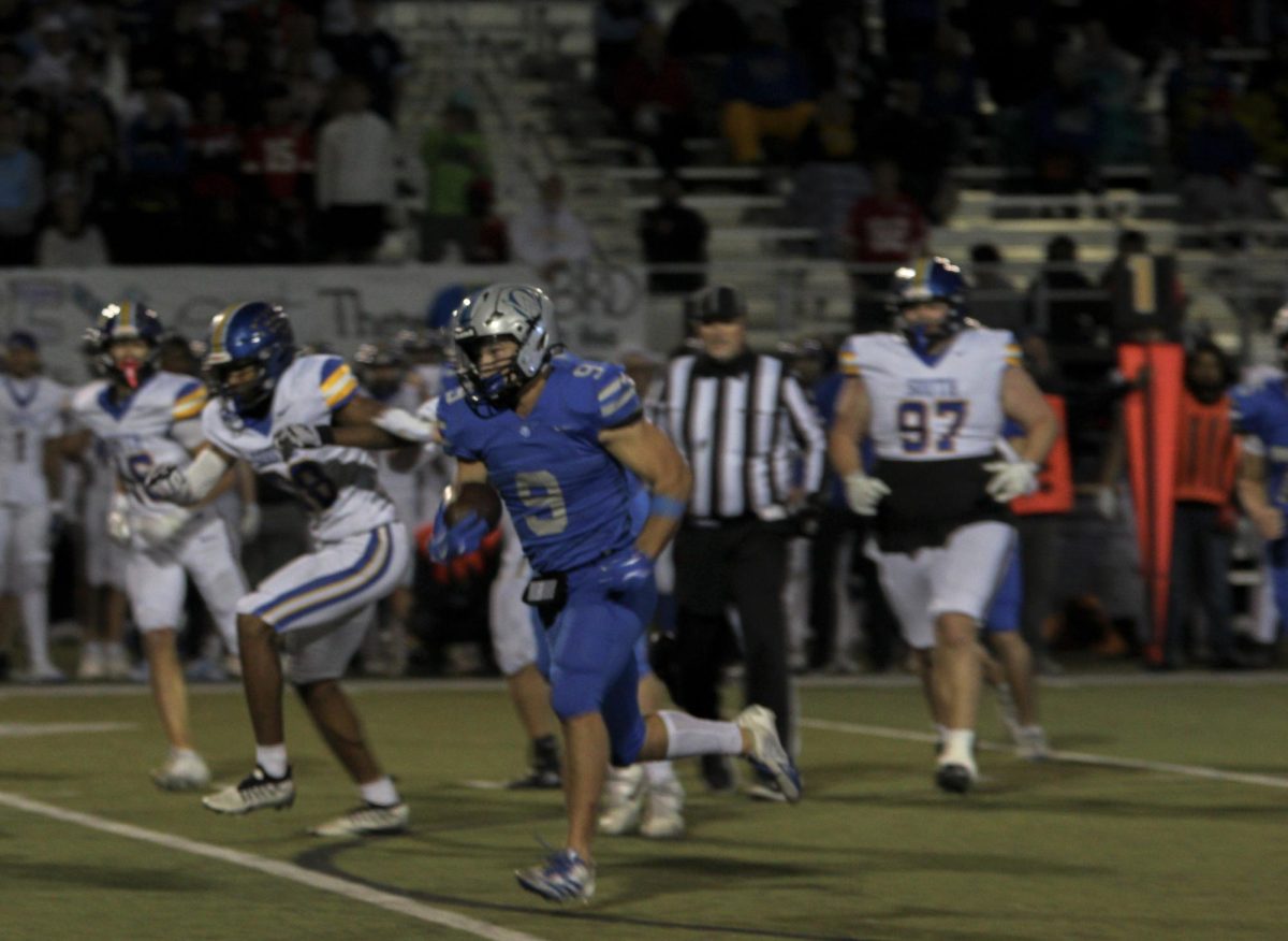Senior Josh Foland rushes away from the defense vs Olathe South