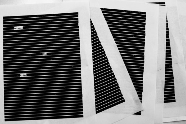 Photo depicting redacted documents saying “Release The Files”